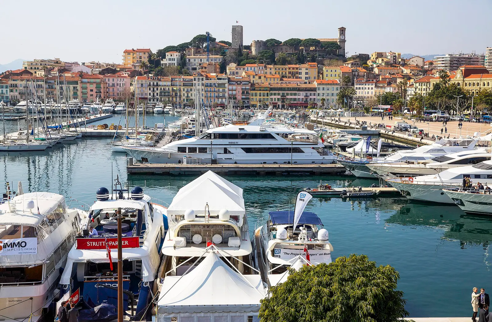 Luxury yachts moored in Cannes harbour below the Suquet old town