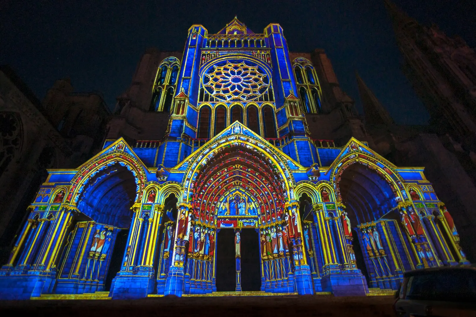 Chartres Cathedral facade lit in blue and gold projections at night