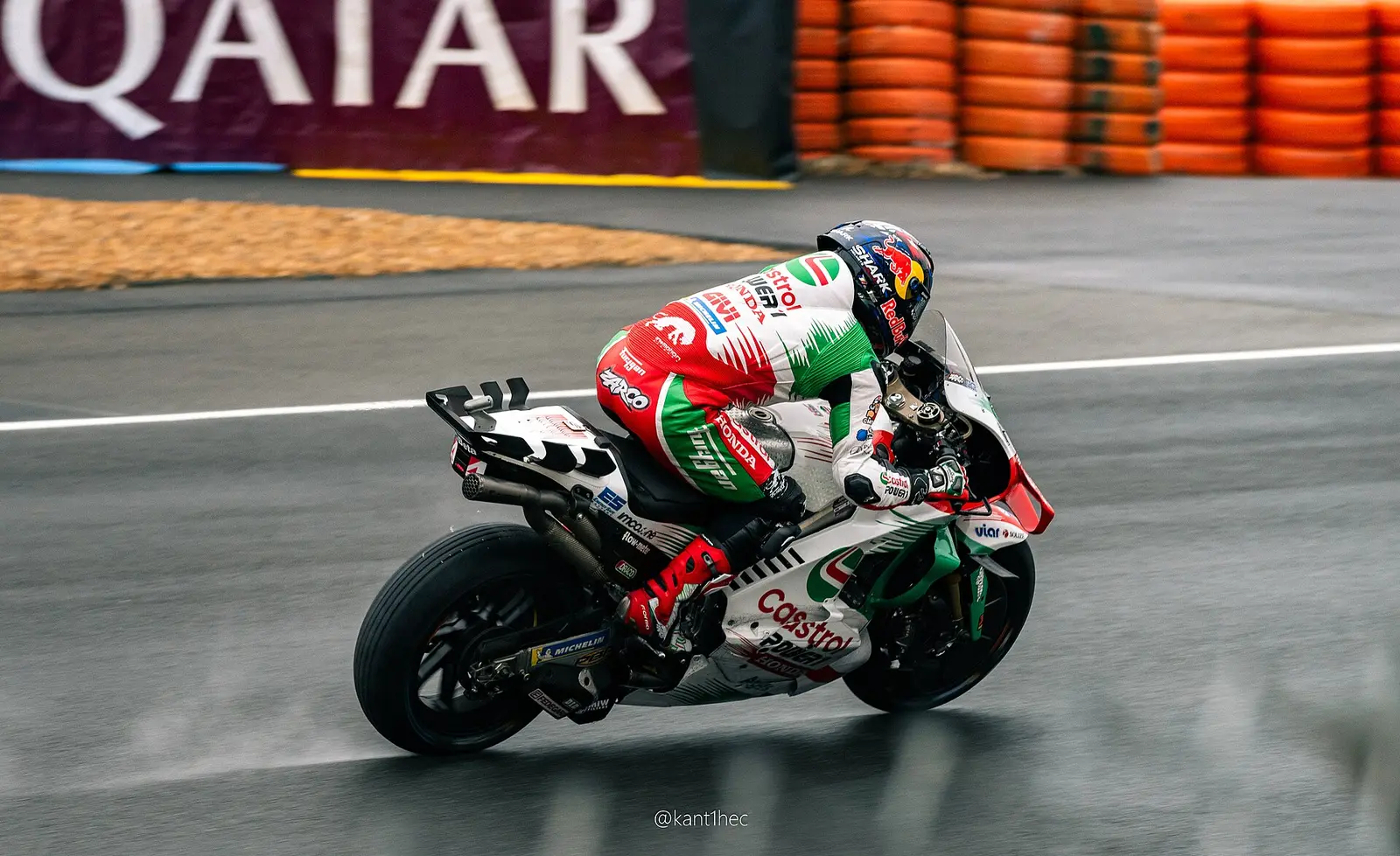 Motorcycle leaning through a corner on the wet Bugatti Circuit at Le Mans