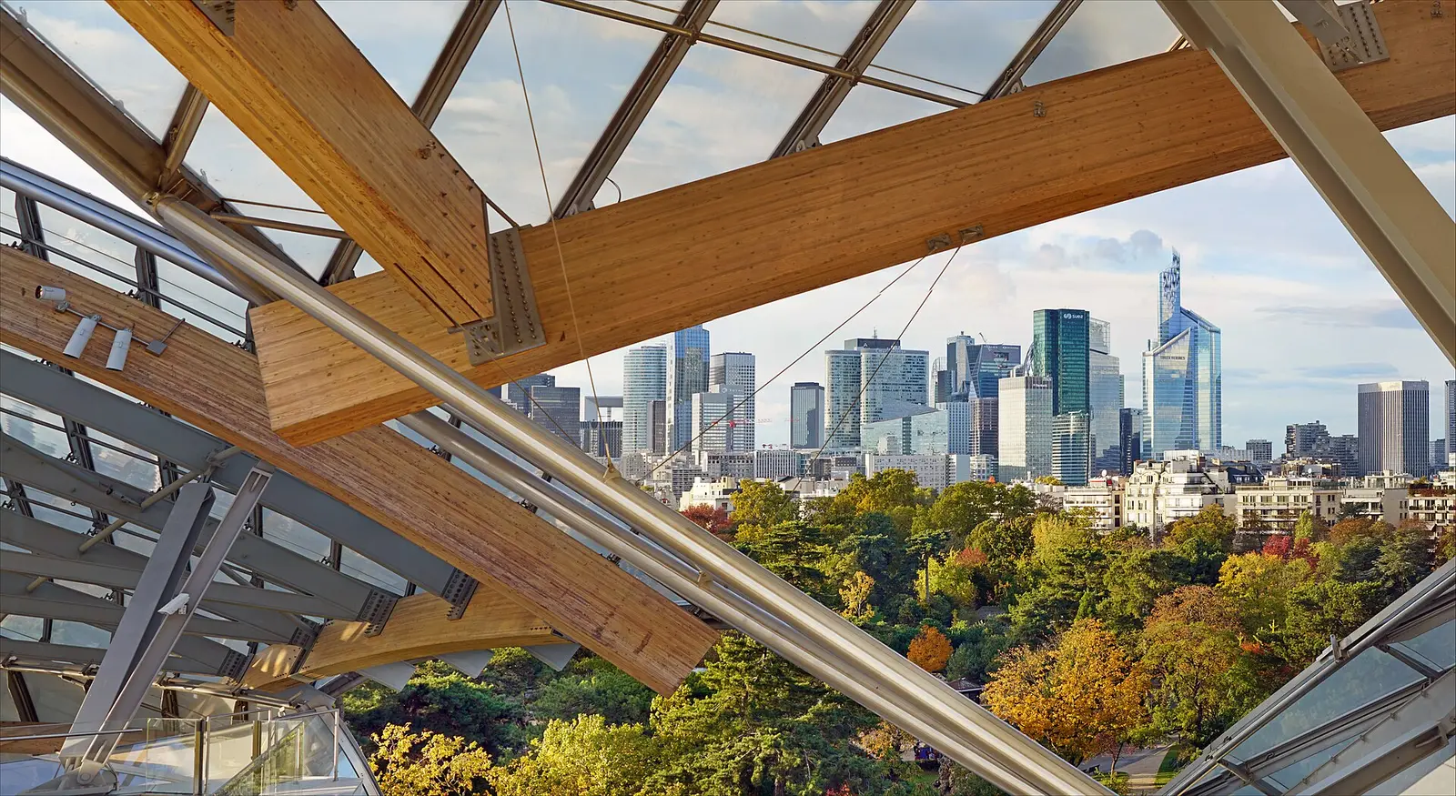 La Défense skyline seen through the timber beams and glass sails of the Fondation Louis Vuitton