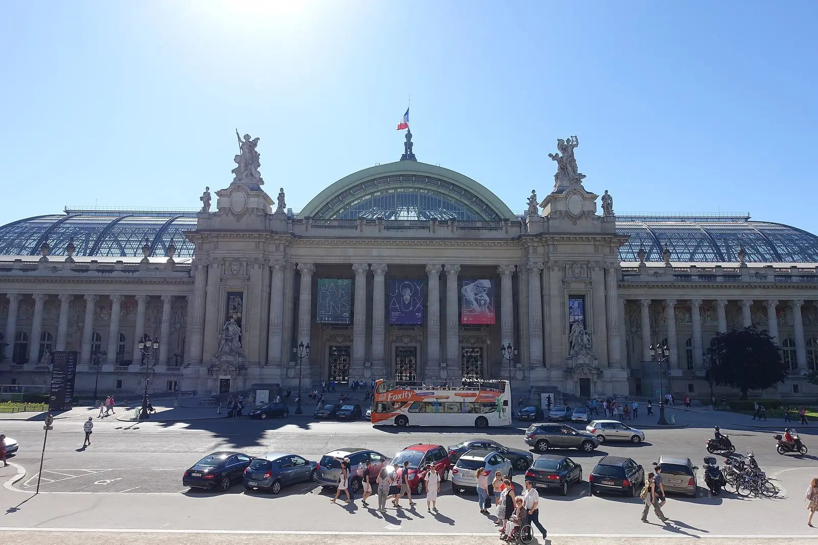 Stone facade and glass roof of the Grand Palais in Paris under a blue sky