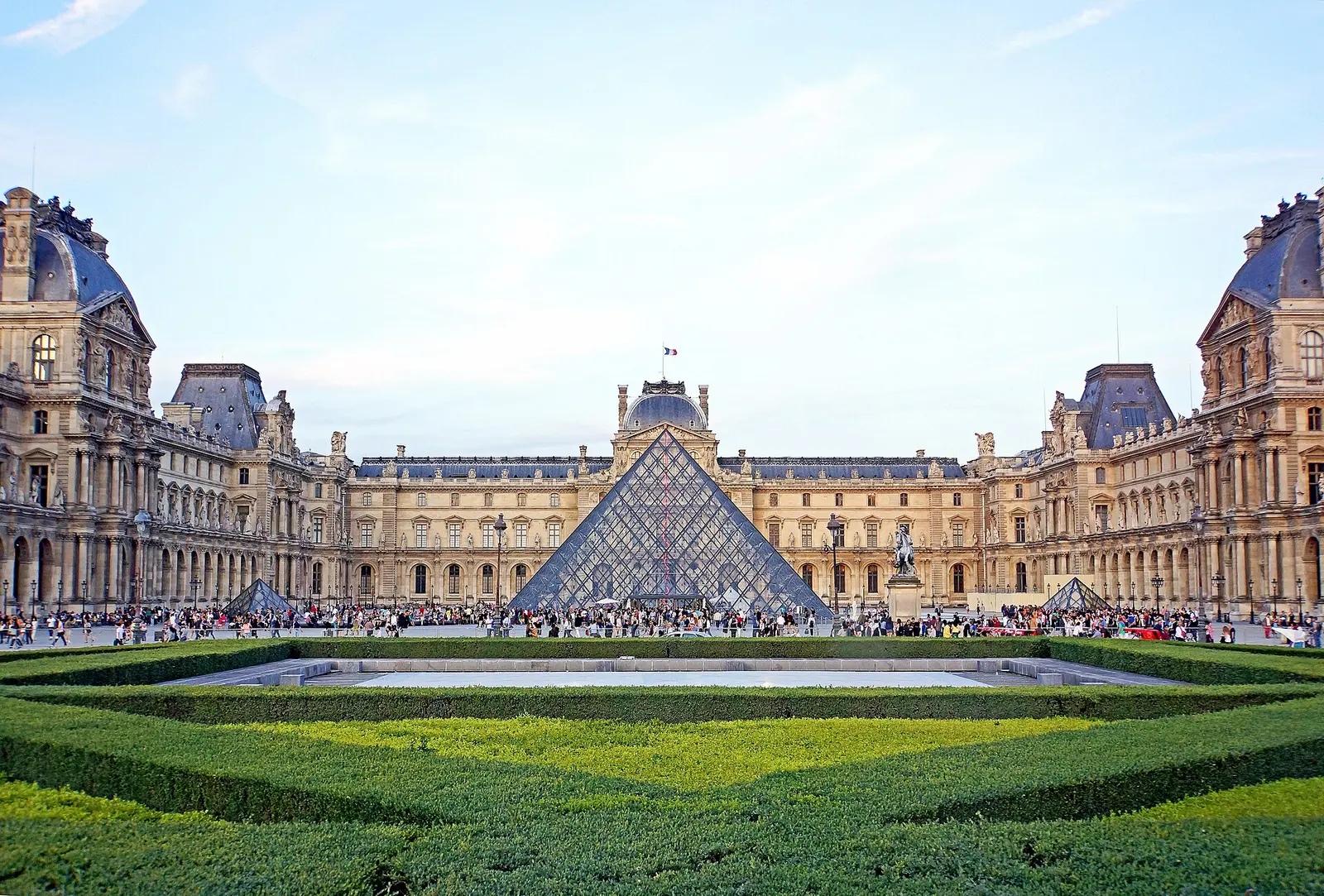 Louvre Pyramid in the Cour Napoléon with the museum wings behind on a sunny day